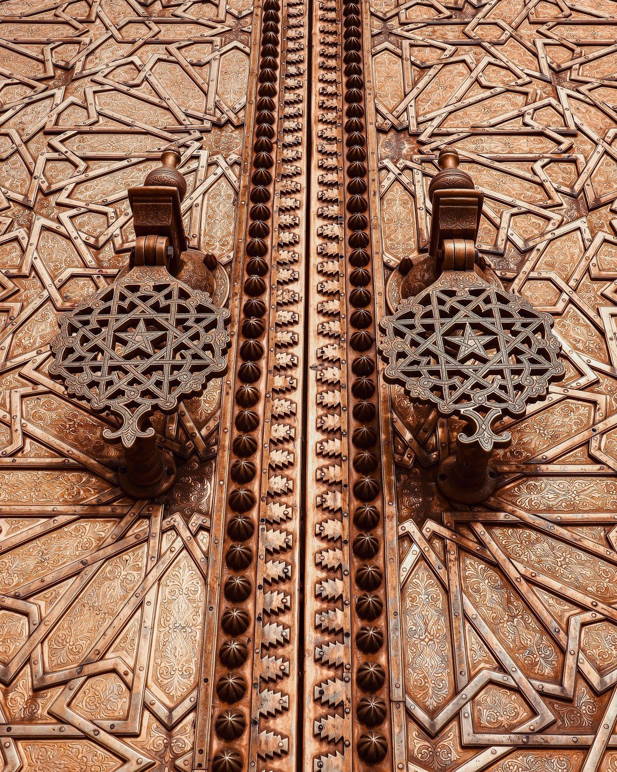 Detail of hand-cast brass door knockers with star motifs