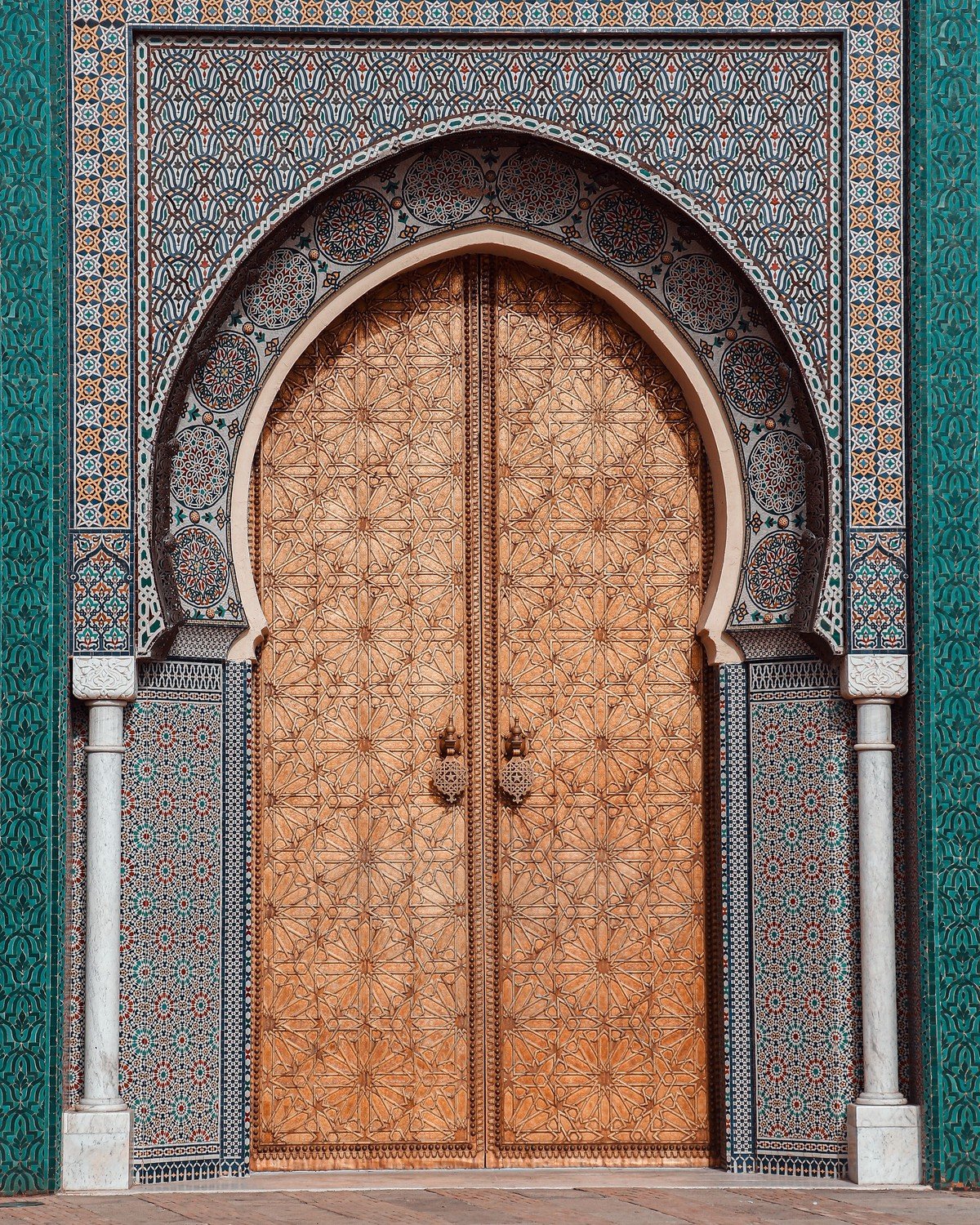 A finished golden Moroccan arched door set in a tiled facade