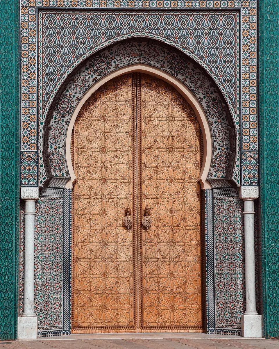 A finished golden Moroccan arched door set in a tiled facade